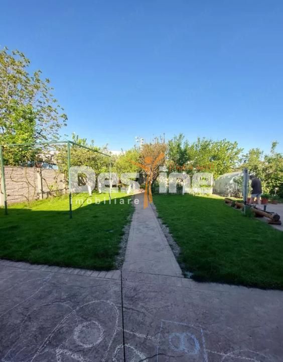Casă individuală cu sistem fotovoltaic, curte amenajată și carport
